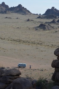Das Auto und ER mitten im Nichts der steinigen Wüste